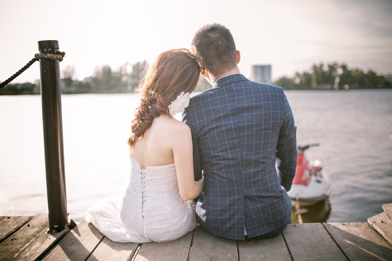 Bride and groom sitting by the water, peaceful vibes – Duo Desire moment.