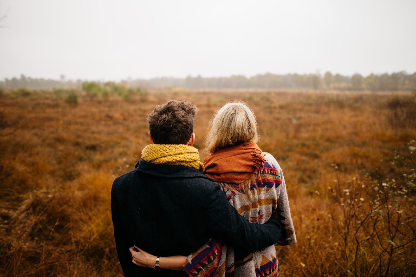 Couple hugging in a field during fall season – Duo Desire love vibes.