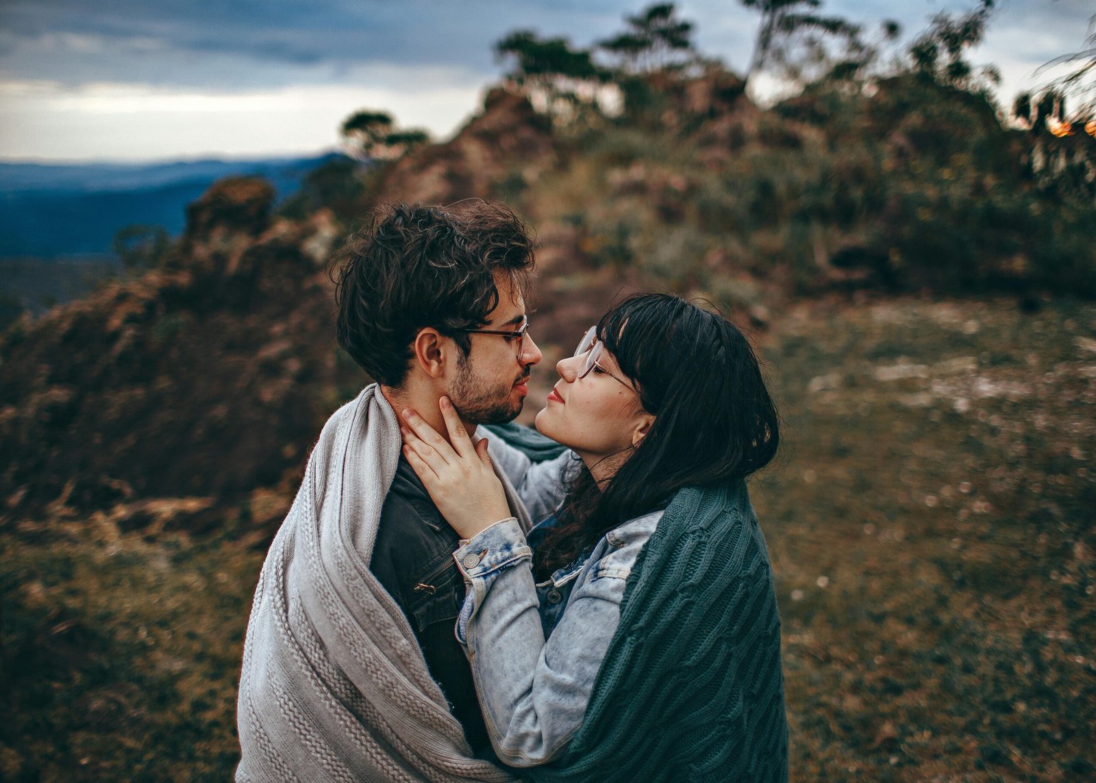 Couple wrapped in blankets sharing a close moment outdoors – Duo Desire connection vibes.
