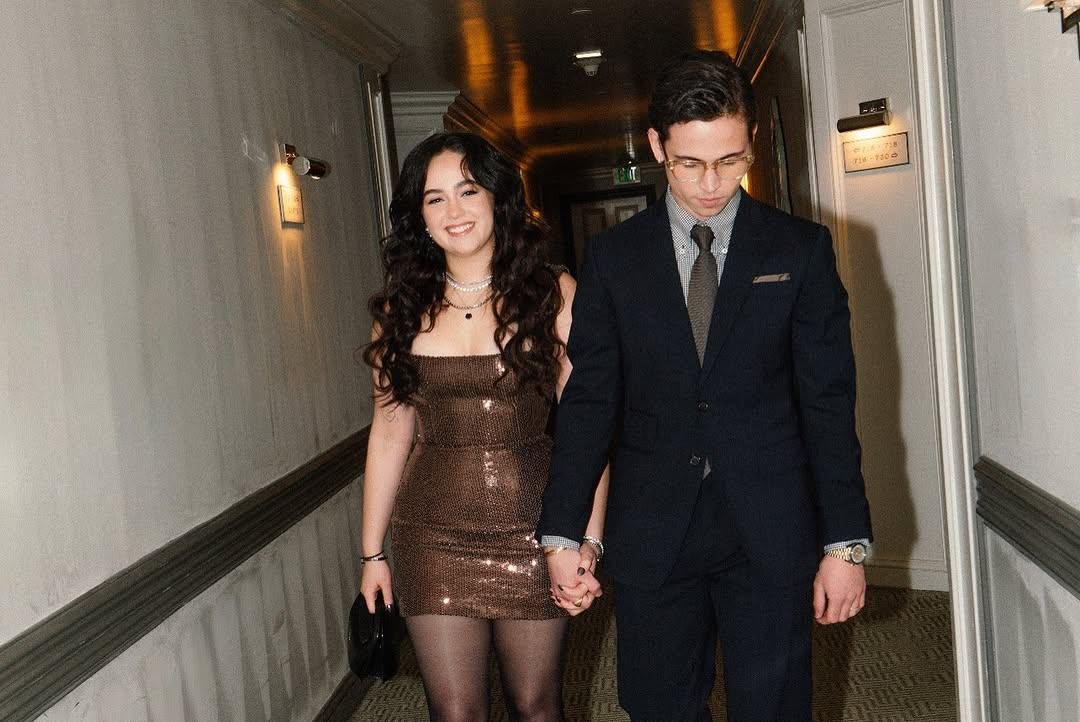 Couple dressed up holding hands in hallway – Duo Desire date night vibes.