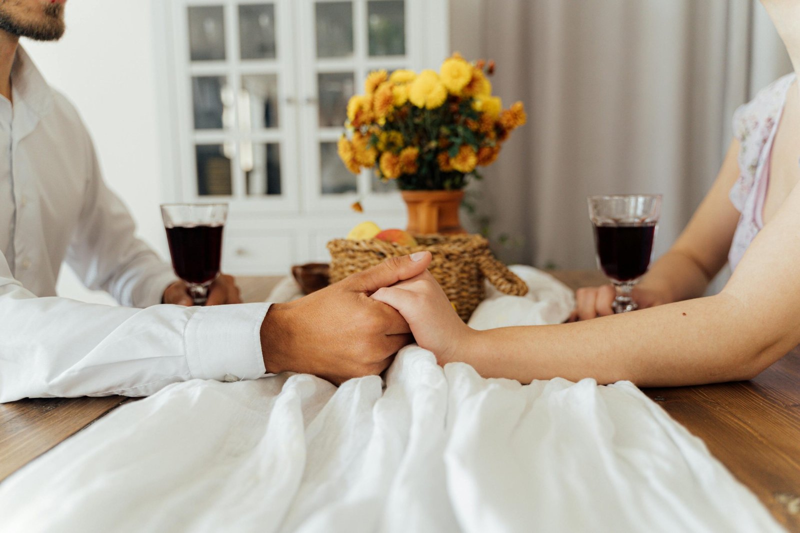 Romantic couple holding hands over dinner with wine – Duo Desire.
