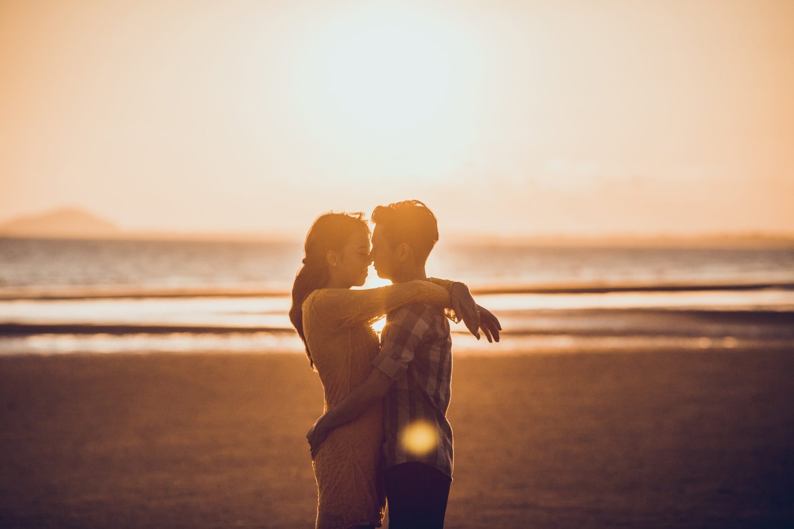 Couple romantically embracing at sunset on beach, relationship goals by Duo Desire.